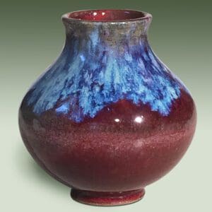 A red vase with blue and white design on it.