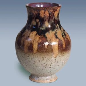 A brown and white vase with purple inside