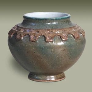 A green vase with brown trim on the side.
